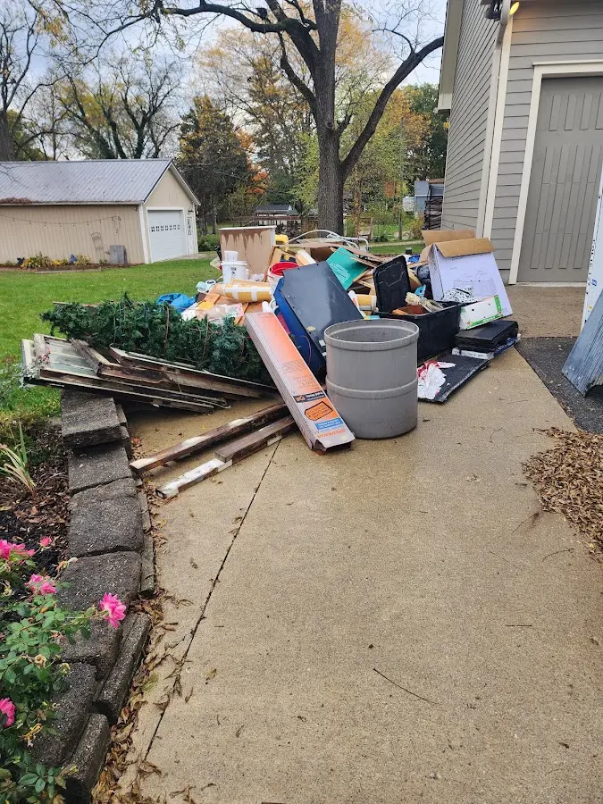 Dumpster being loaded with debris for Estate Cleanout Dumpster Rental in Macomb